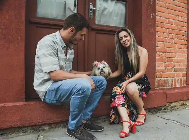 Two students petting their Shih Tzu.